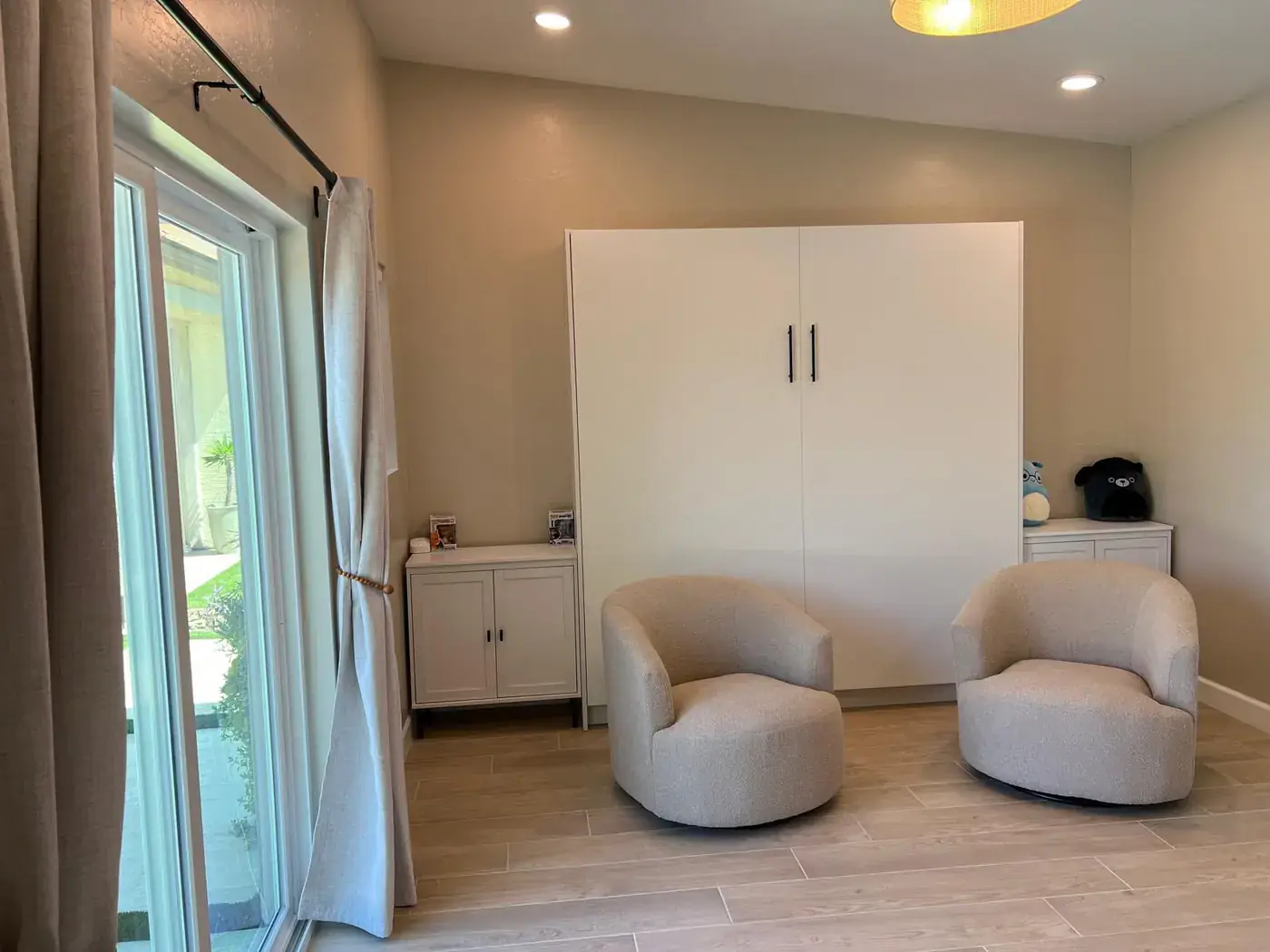 The interior lounge with two armchairs and a white wall-bed cabinet.