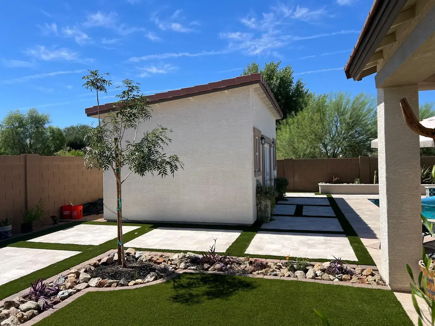 Side wall of the finished casita with paver walkway, turf and desert planting.