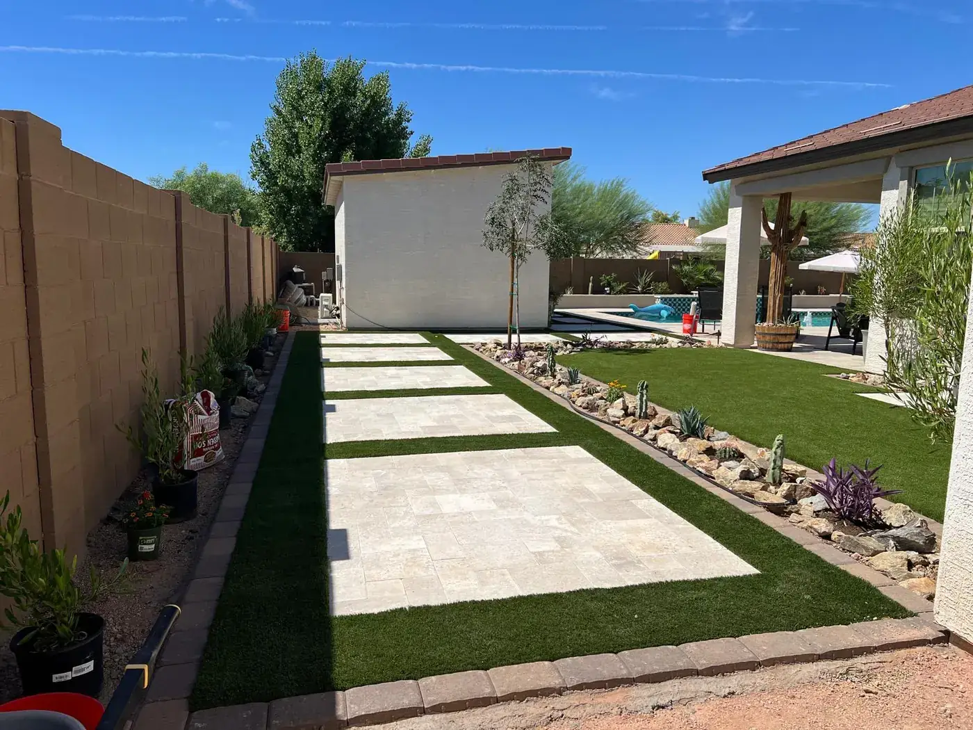 Travertine walkway with turf joints leading from the casita to the main house patio.